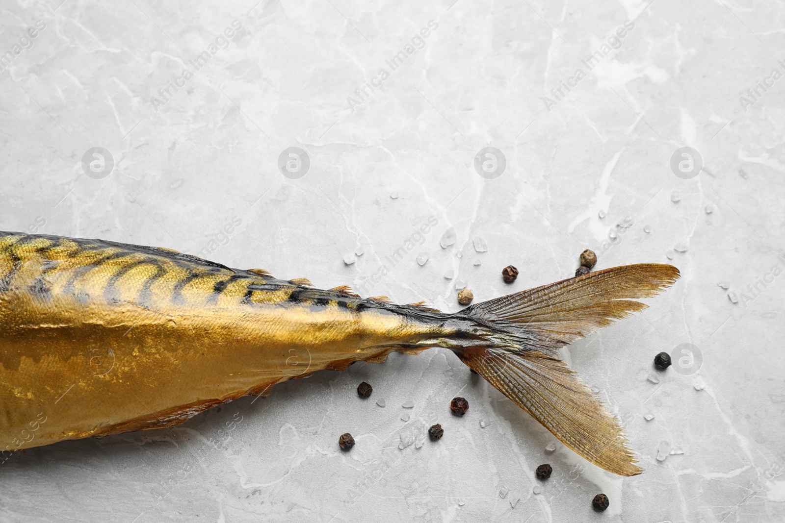 Photo of Tasty smoked fish on light grey marble table, closeup