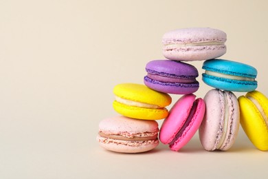 Delicious colorful macarons on beige background. Space for text