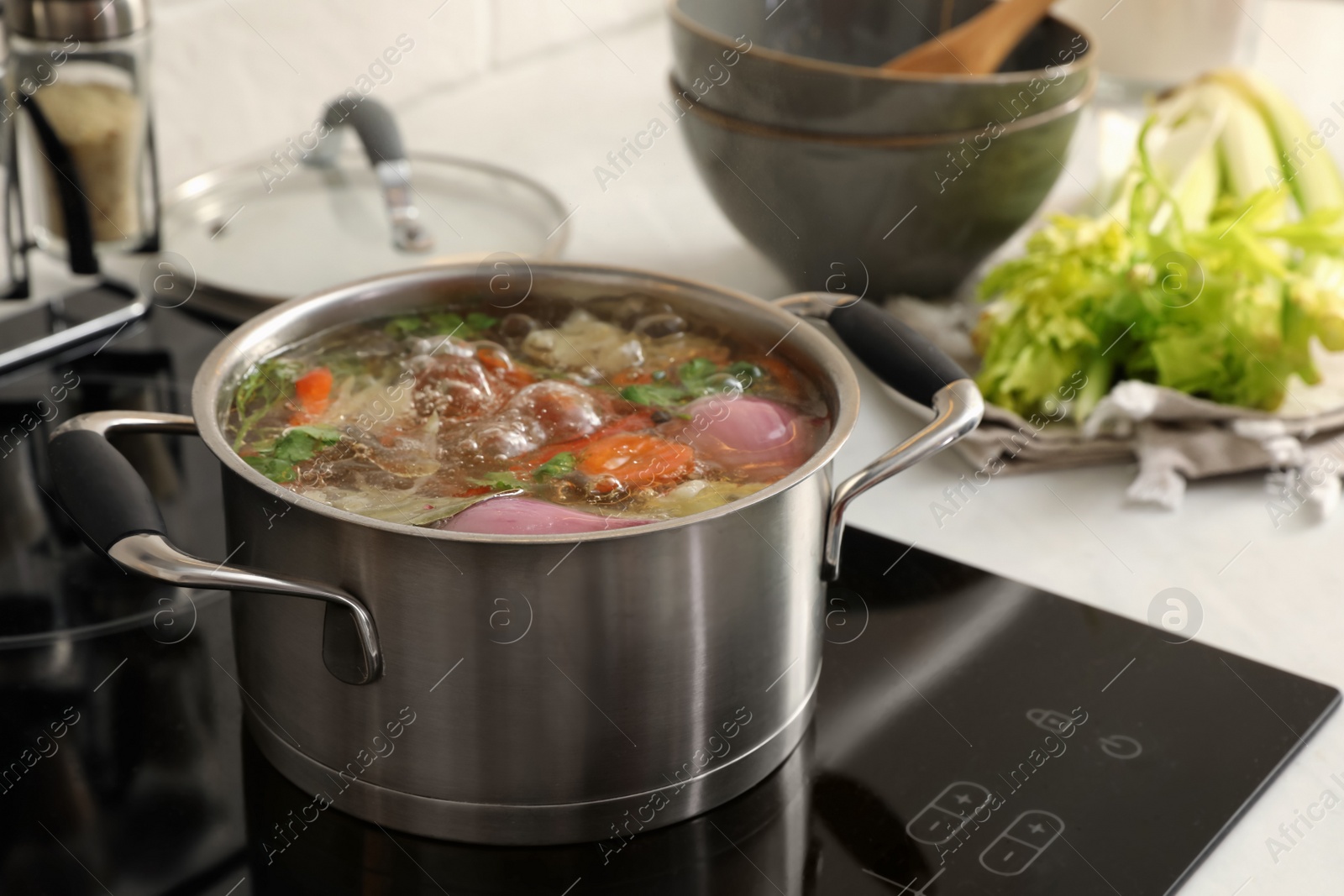 Photo of Pot of delicious vegetable bouillon on stove in kitchen