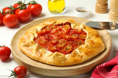 Photo of Tasty tomato galette (Caprese galette) on white wooden table, closeup