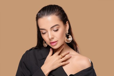 Photo of Portrait of young woman with beautiful makeup on light brown background