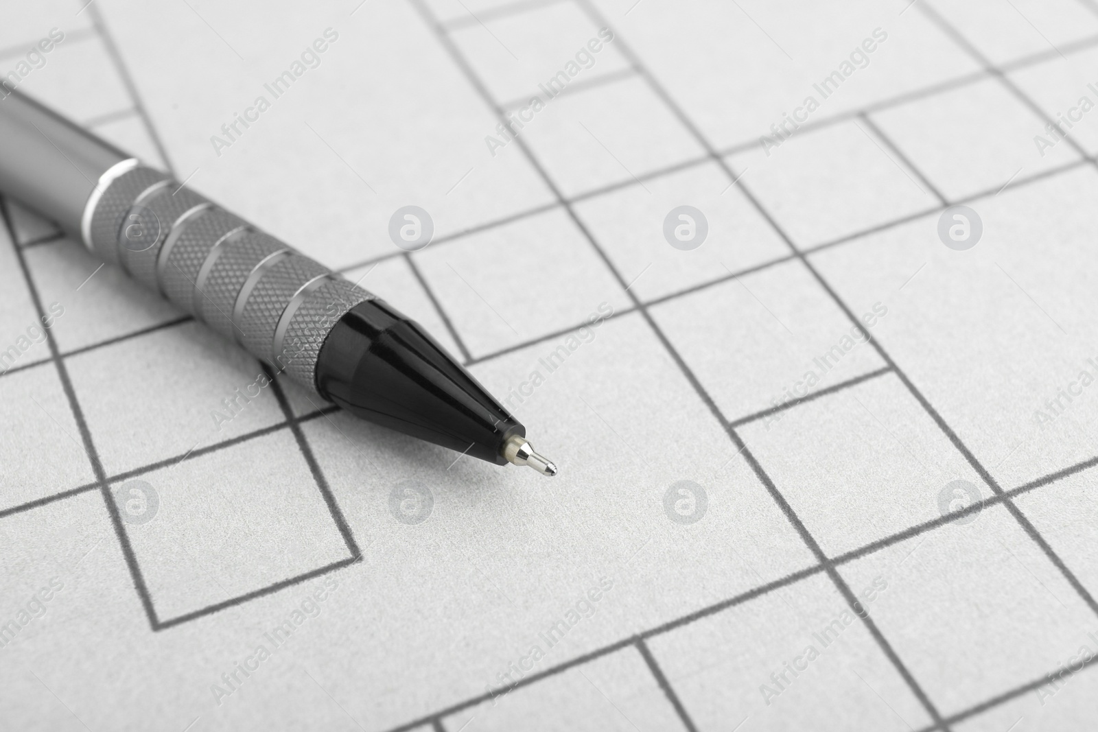 Photo of Pen on blank crossword, closeup. Space for text