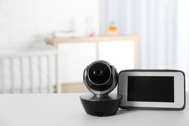 Photo of Baby monitor with camera on table in room, space for text. Video nanny
