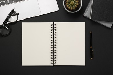 Photo of Flat lay composition with notebook and laptop on black table