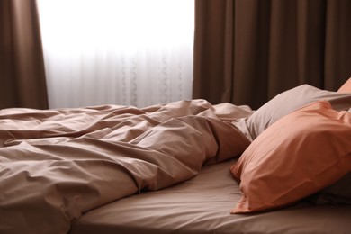 Photo of Bed with orange and brown linens in stylish room