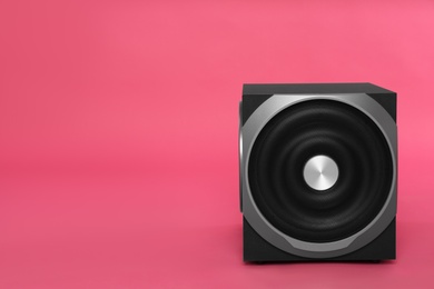Photo of Modern subwoofer on pink background, space for text. Powerful audio speaker
