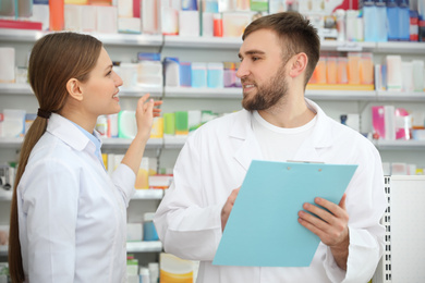 Professional pharmacists working together in modern drugstore