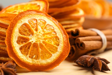 Dry orange slices, anise stars and cinnamon sticks on wooden board, closeup