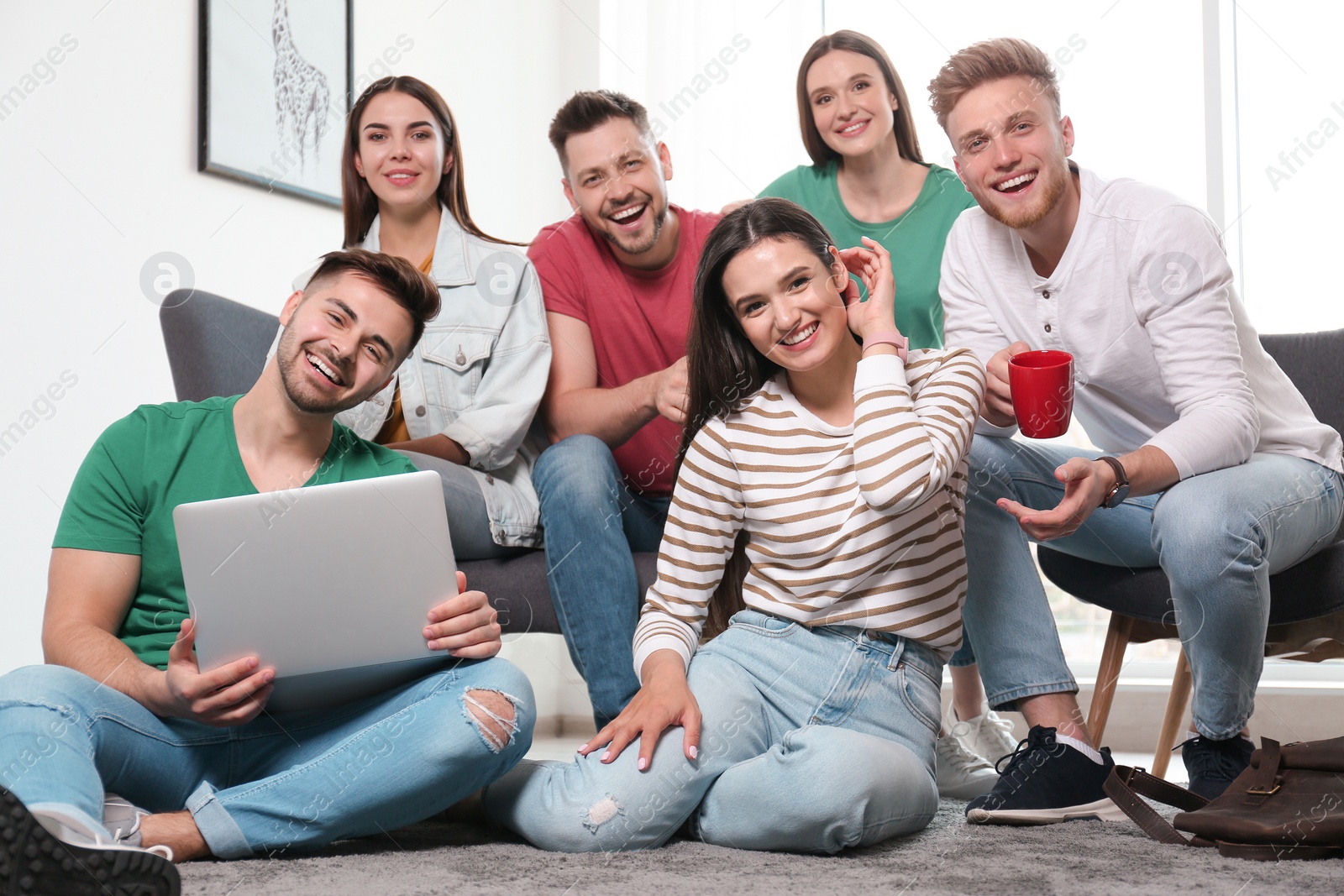 Photo of Group of happy people with laptop in living room