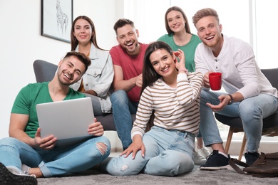 Photo of Group of happy people with laptop in living room