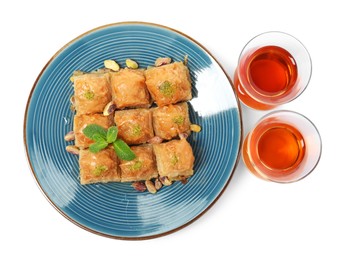 Photo of Delicious baklava with pistachios and hot tea on white background, top view