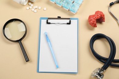 Photo of Endocrinology. Flat lay composition with clipboard and model of thyroid gland on beige background