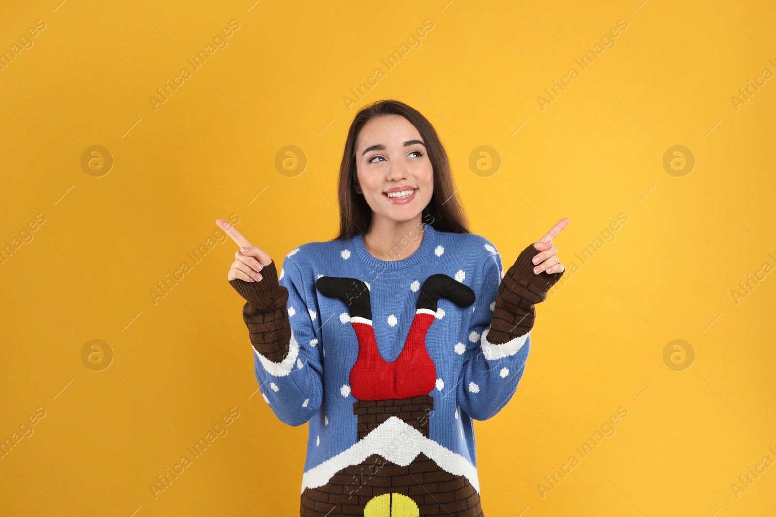 Photo of Young woman in Christmas sweater on yellow background