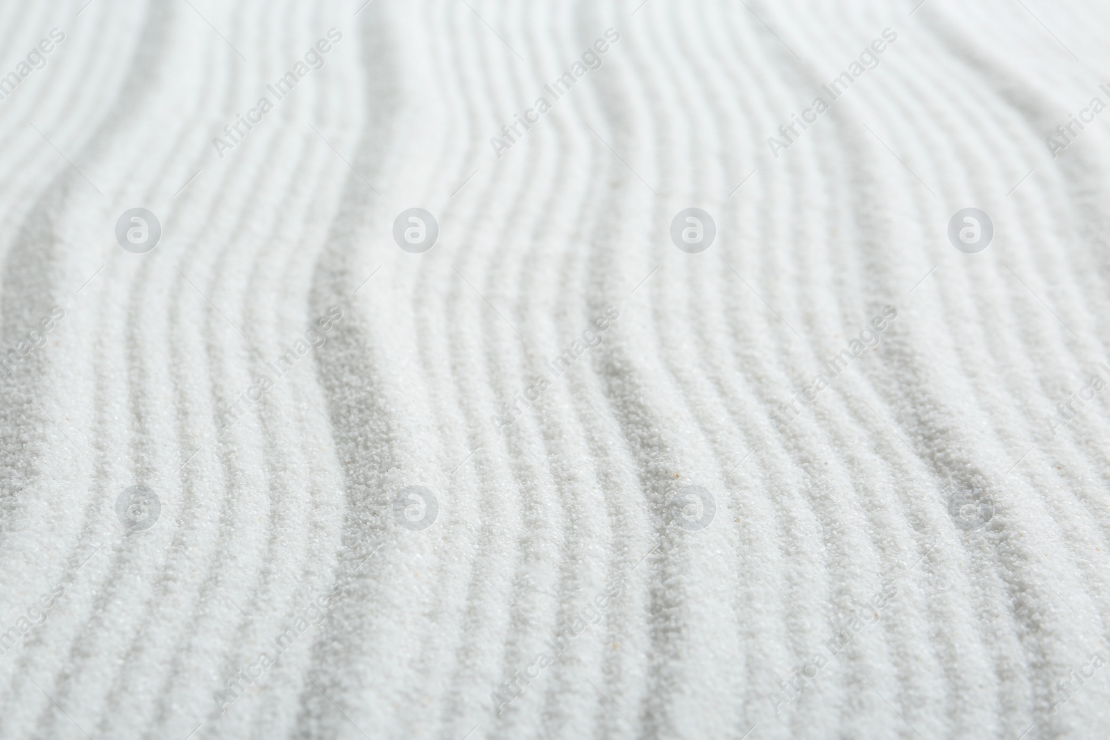 Photo of Zen rock garden. Wave pattern on white sand, closeup