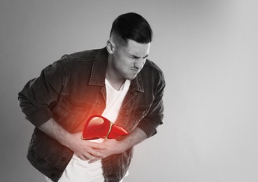 Sick man suffering from pain and illustration of unhealthy liver on light background. Hepatitis disease