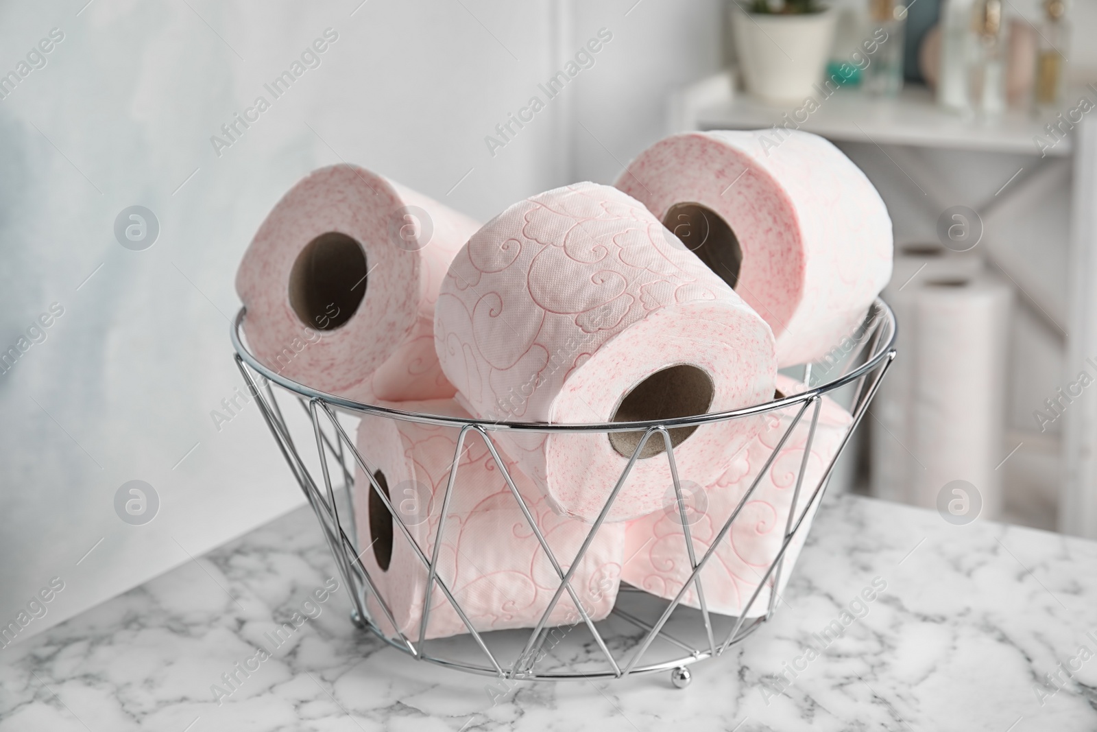 Photo of Bowl with toilet paper rolls on table