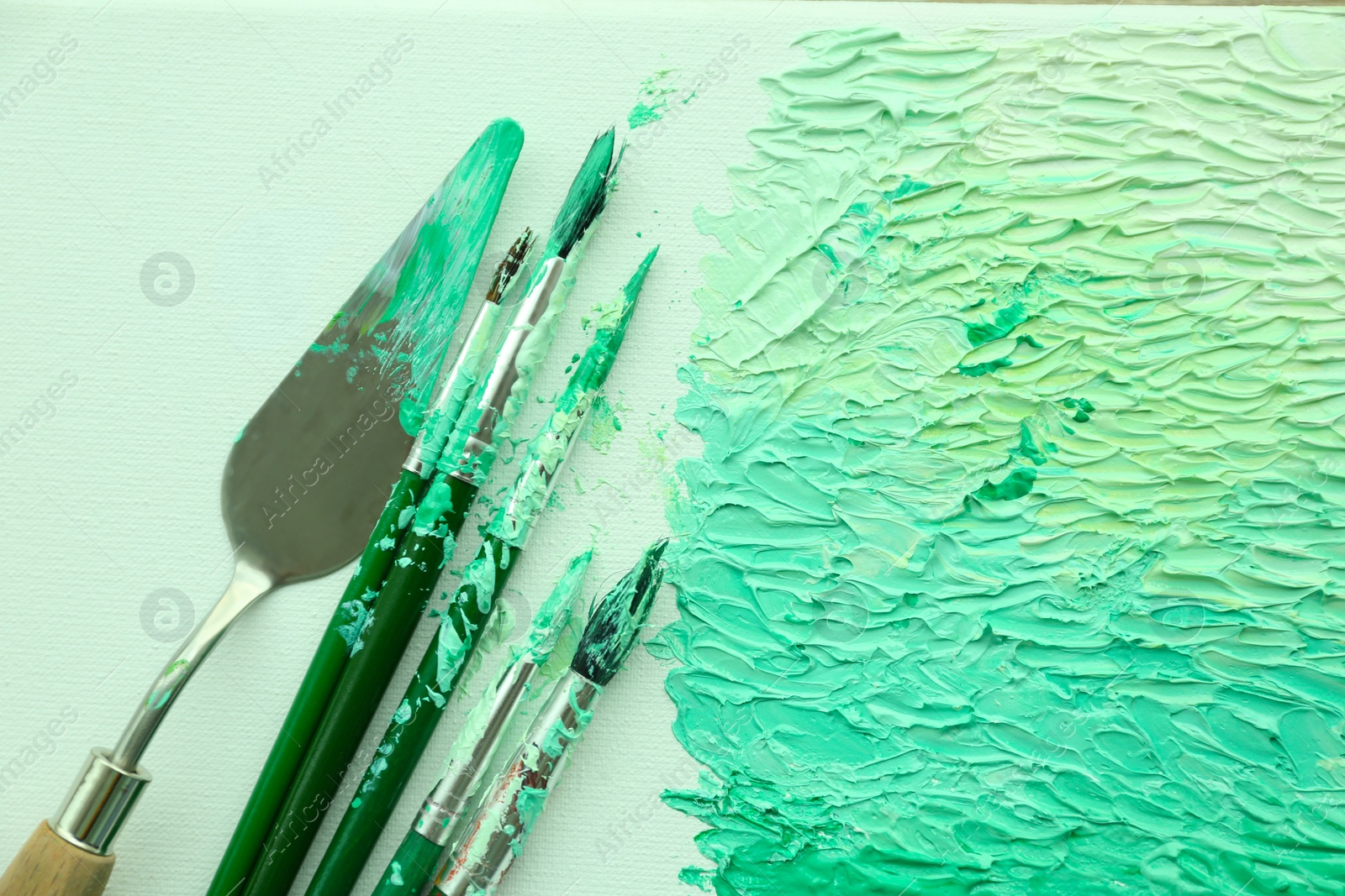 Photo of Abstract colorful artwork and brushes, top view