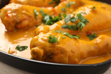 Photo of Tasty chicken curry with parsley on wooden table, closeup