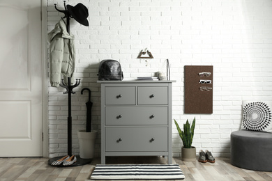 Grey chest of drawers in stylish hallway interior