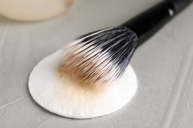 Cleaning makeup brush on grey table, closeup