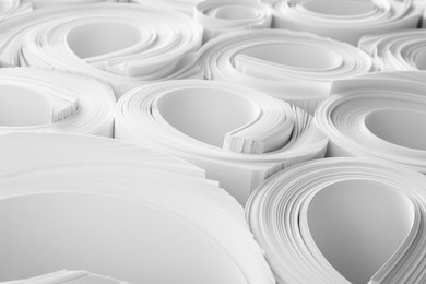 Photo of Rolled white paper sheets as background, closeup