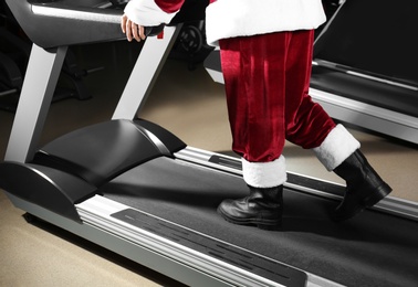 Photo of Authentic Santa Claus training on treadmill in modern gym, closeup