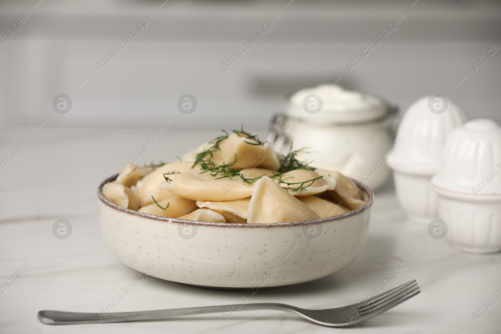 Photo of Delicious dumplings with dill on table in kitchen, closeup