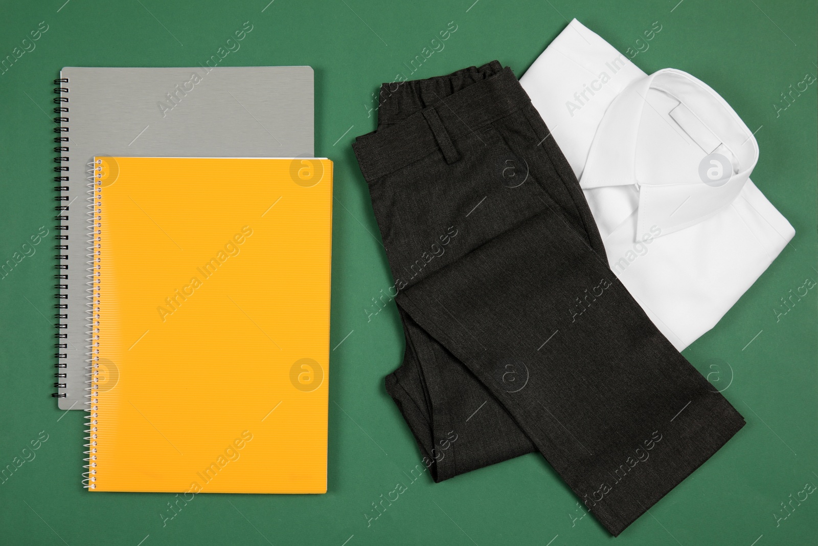 Photo of School uniform for boy and notebooks on color background, top view