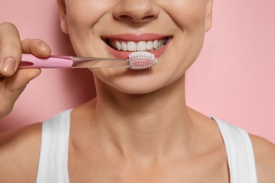 Woman with toothbrush on color background, closeup