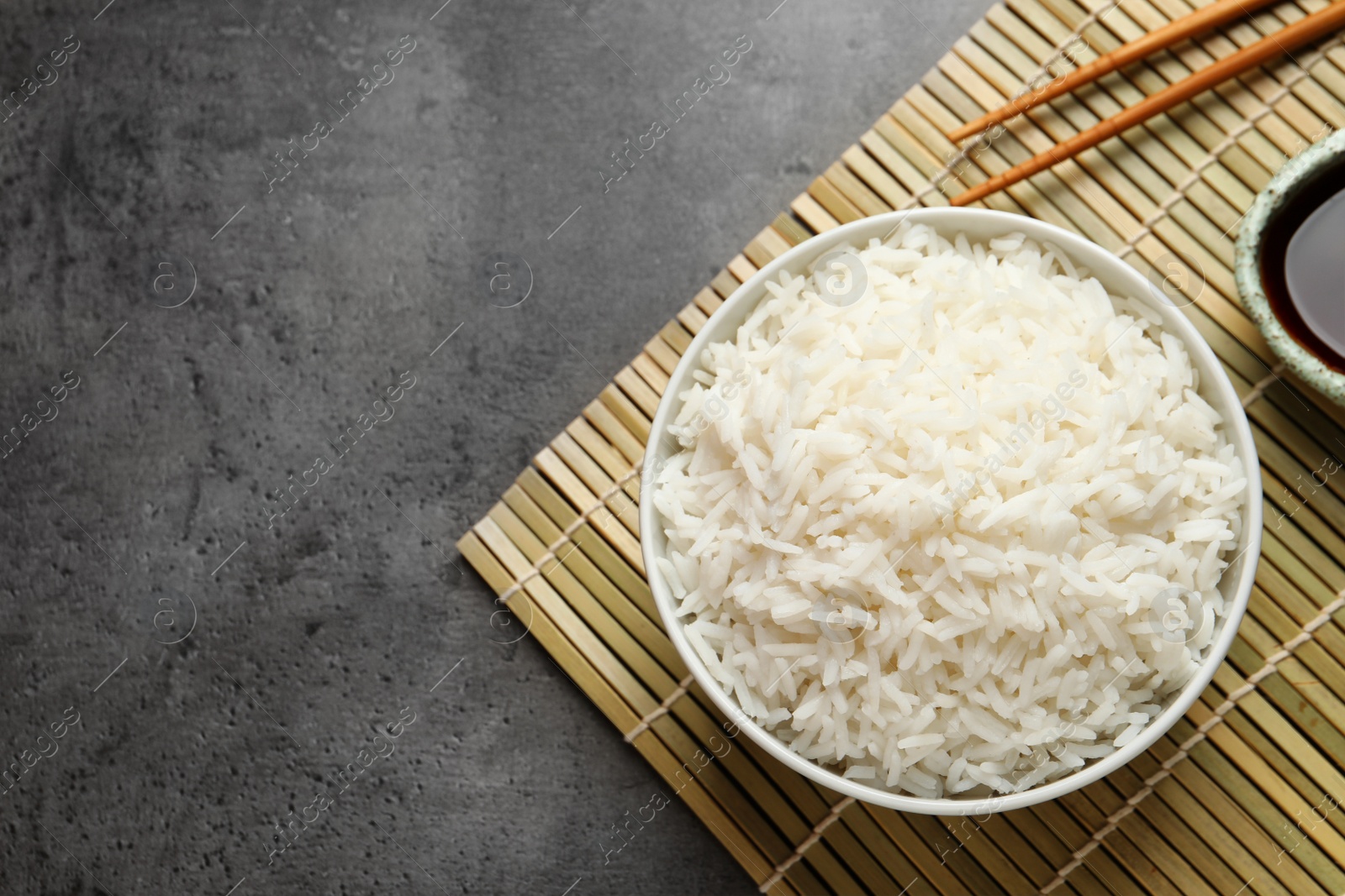 Photo of Bowl of cooked white rice served on table, flat lay. Space for text