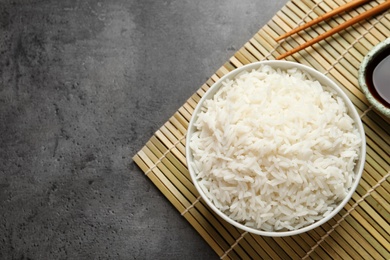 Bowl of cooked white rice served on table, flat lay. Space for text