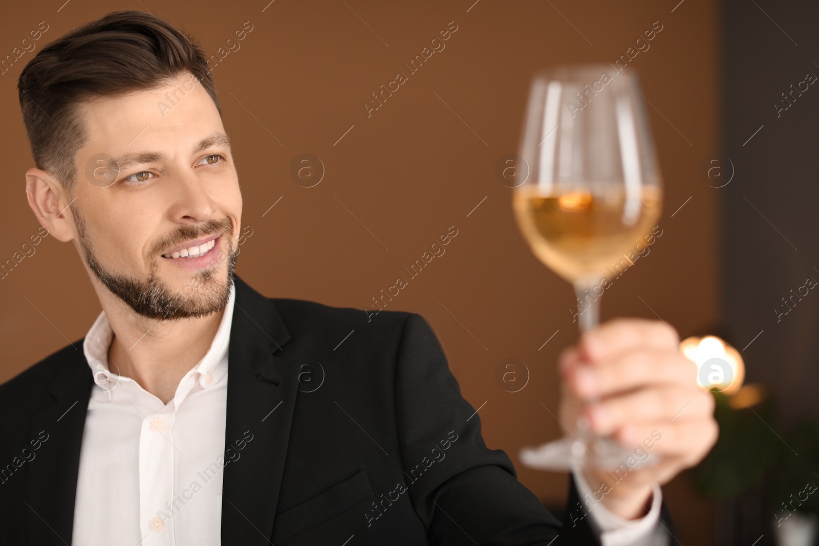 Photo of Young man with glass of wine indoors