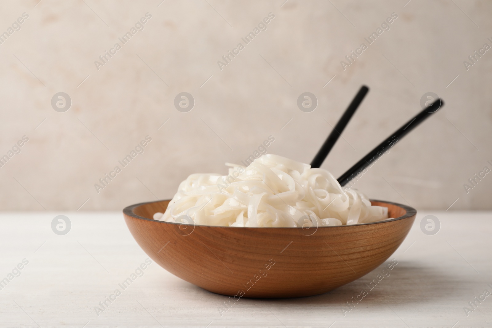 Photo of Bowl with rice noodles on table. Delicious pasta