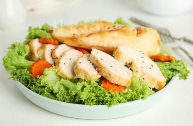 Photo of Tasty cooked chicken fillet with fresh salad served on white table. Healthy meals from air fryer
