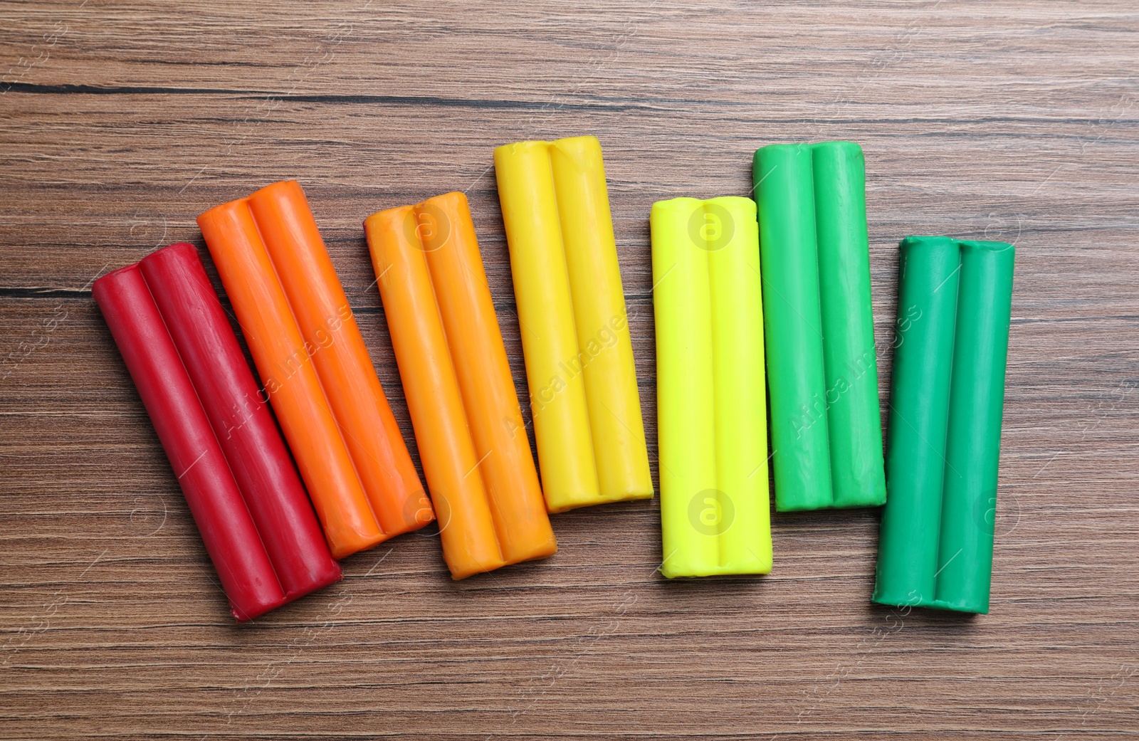 Photo of Many different colorful plasticine on wooden table, flat lay