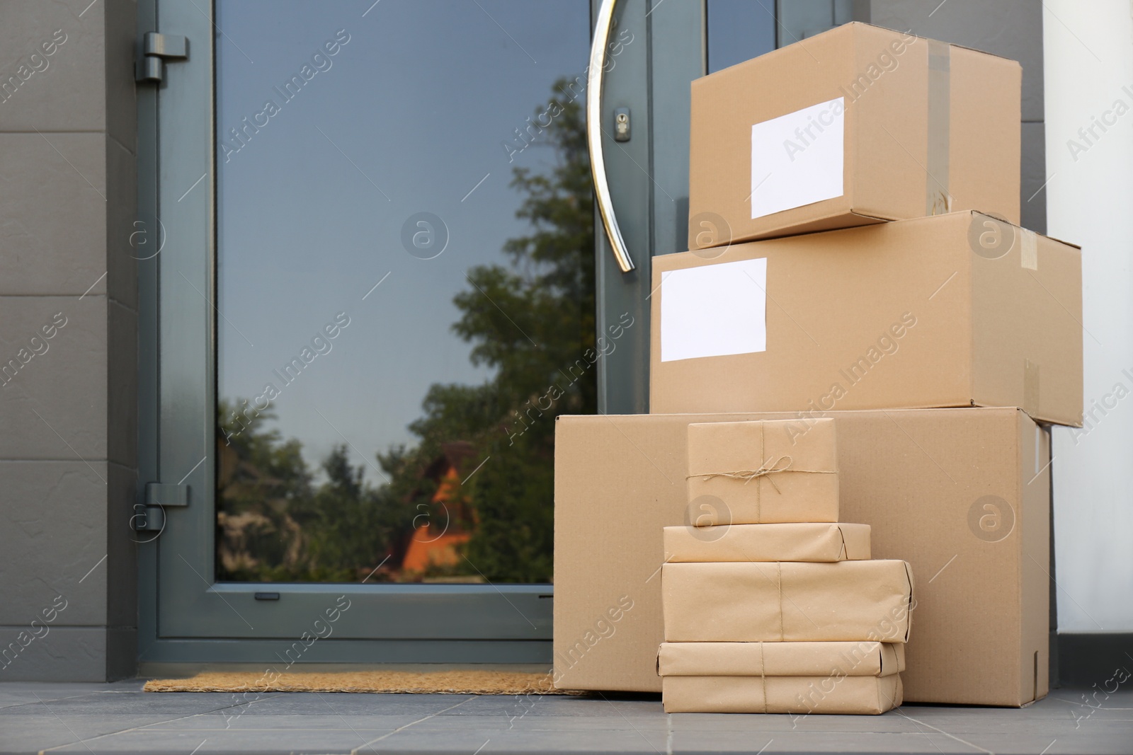 Photo of Cardboard boxes near door. Parcel delivery service