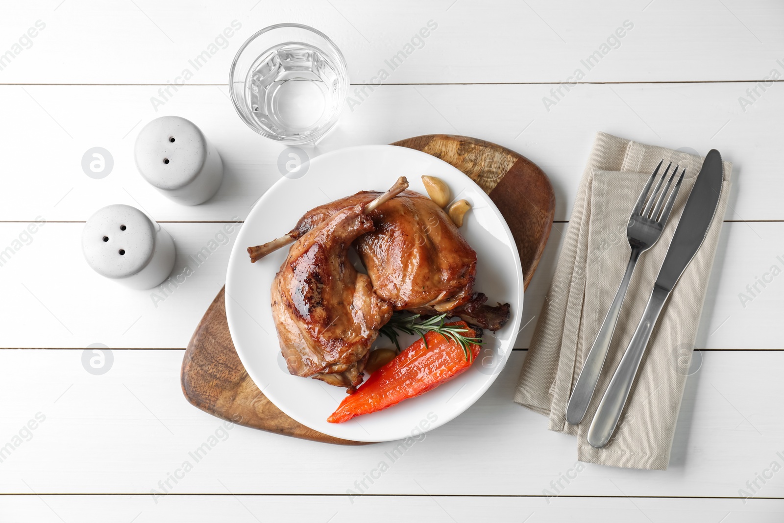 Photo of Tasty cooked rabbit meat served on white wooden table, flat lay