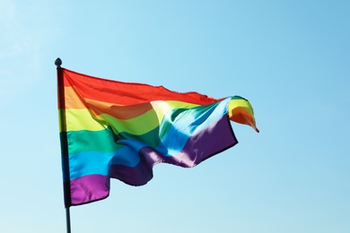 Photo of Rainbow gay flag against blue sky. LGBT concept
