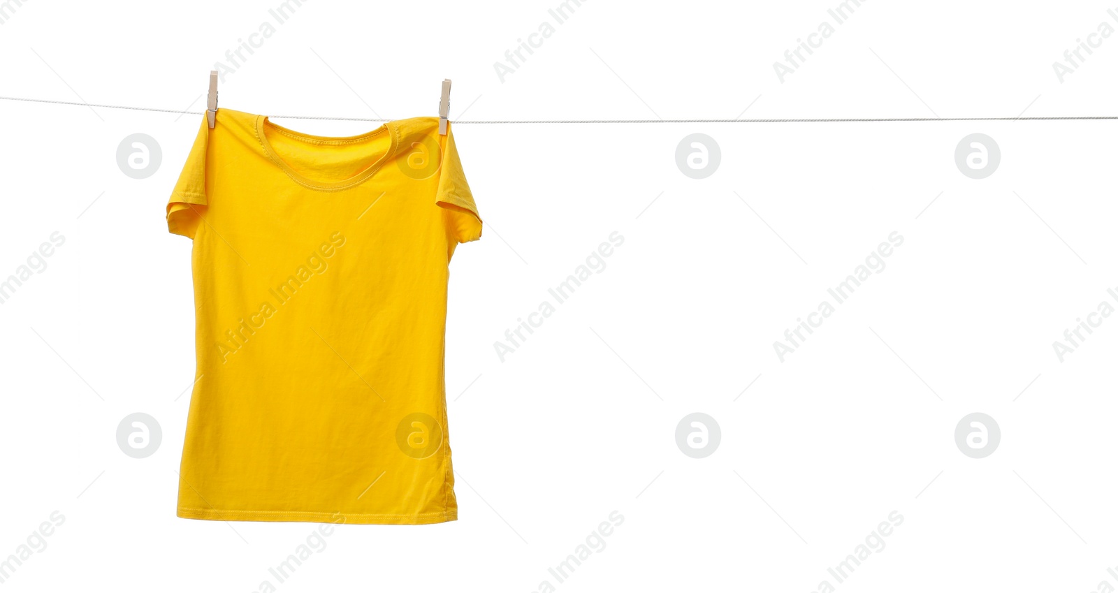 Photo of Yellow t-shirt drying on washing line against white background