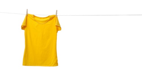 Photo of Yellow t-shirt drying on washing line against white background