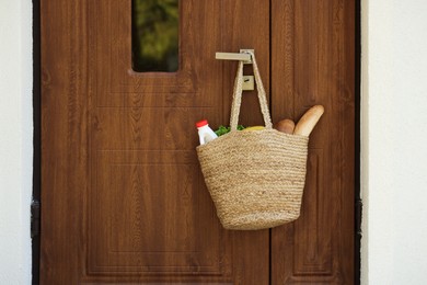 Photo of Helping neighbours. Bag of products hanging on door outdoors