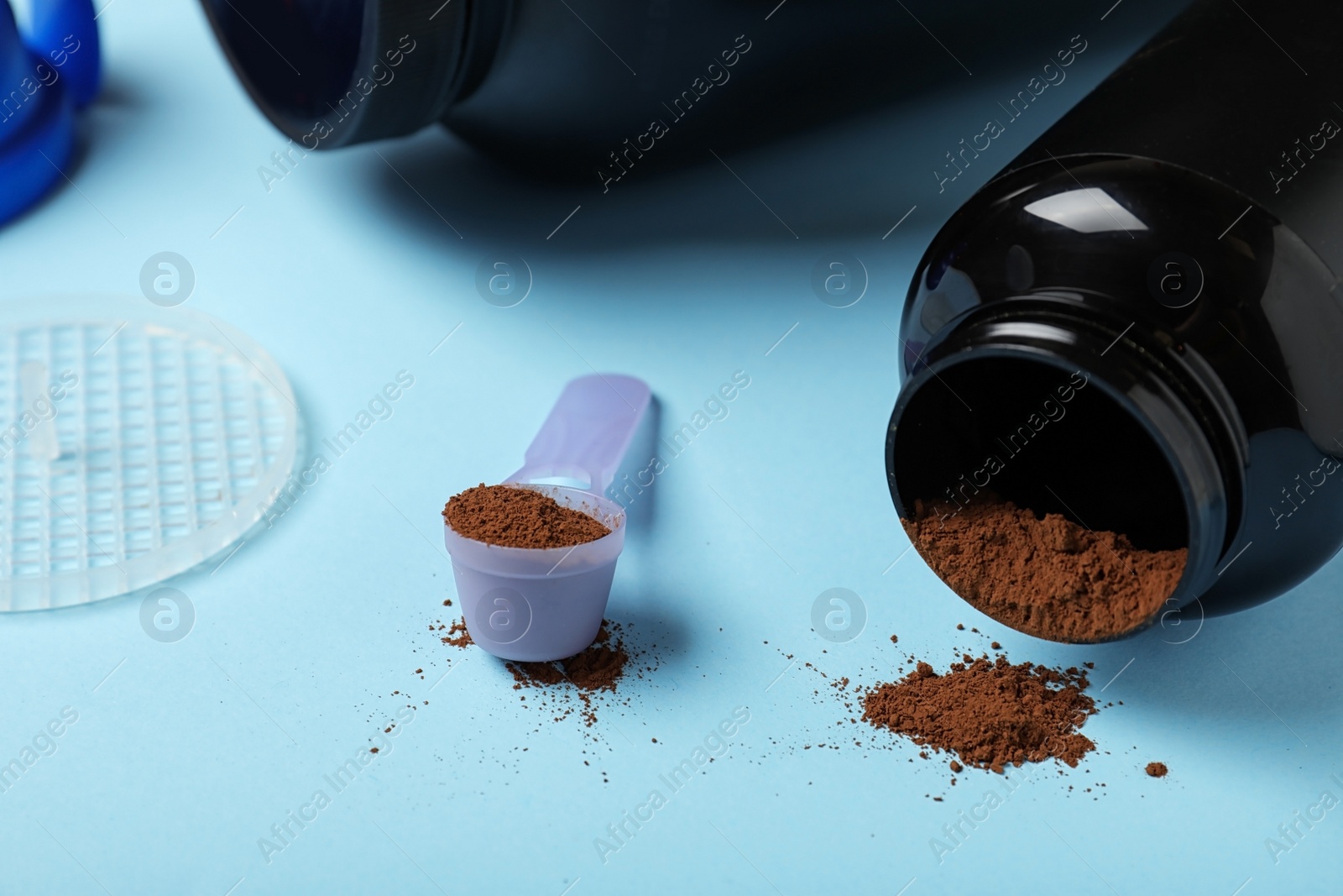 Photo of Measuring scoop and jar with protein powder on table