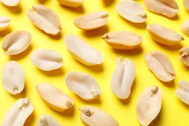 Photo of Many fresh peanuts on yellow background. Healthy snack