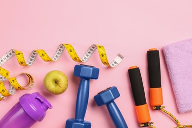 Photo of Flat lay composition with dumbbells on pink background