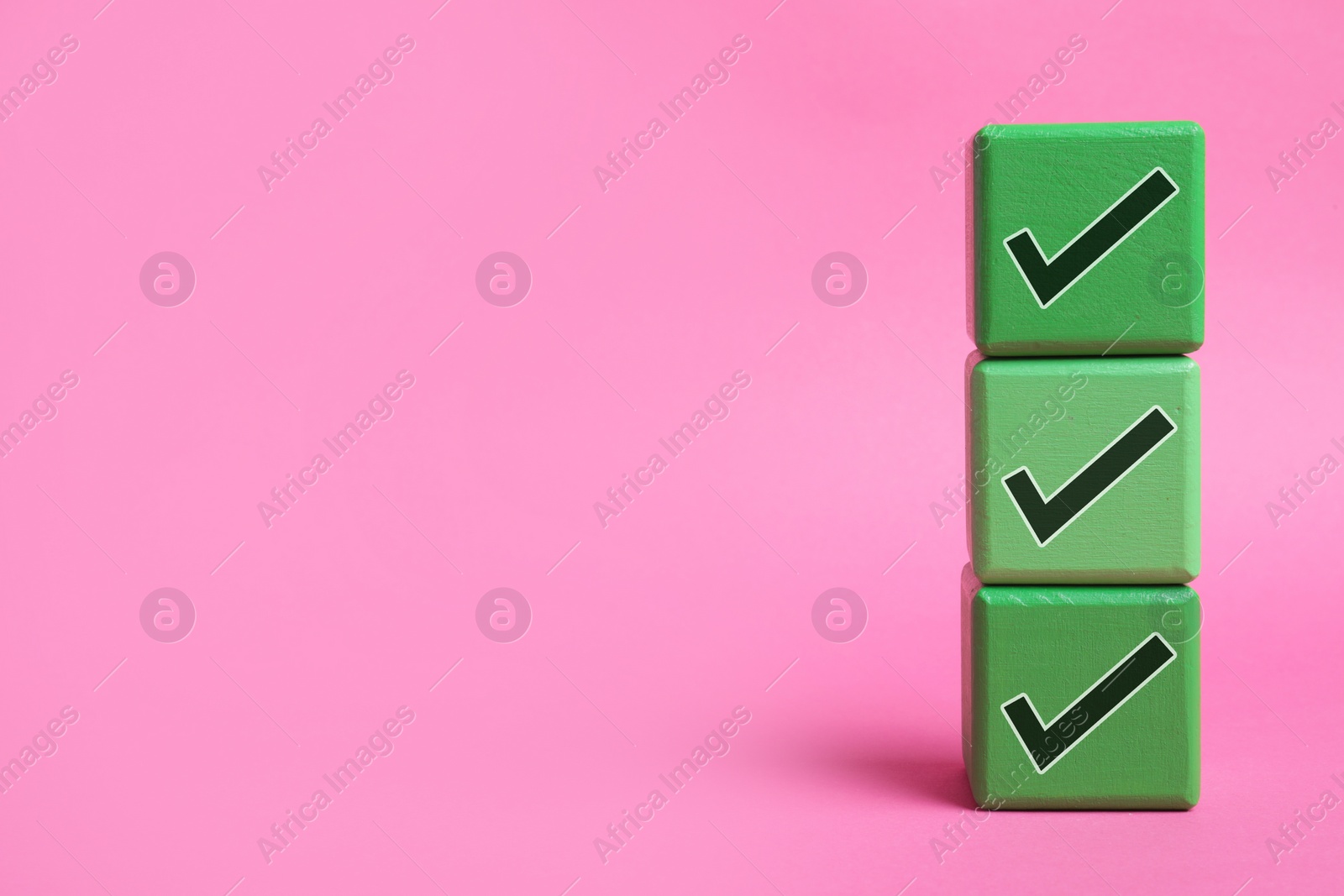 Image of Stacked cubes with check marks on pink background. Space for text