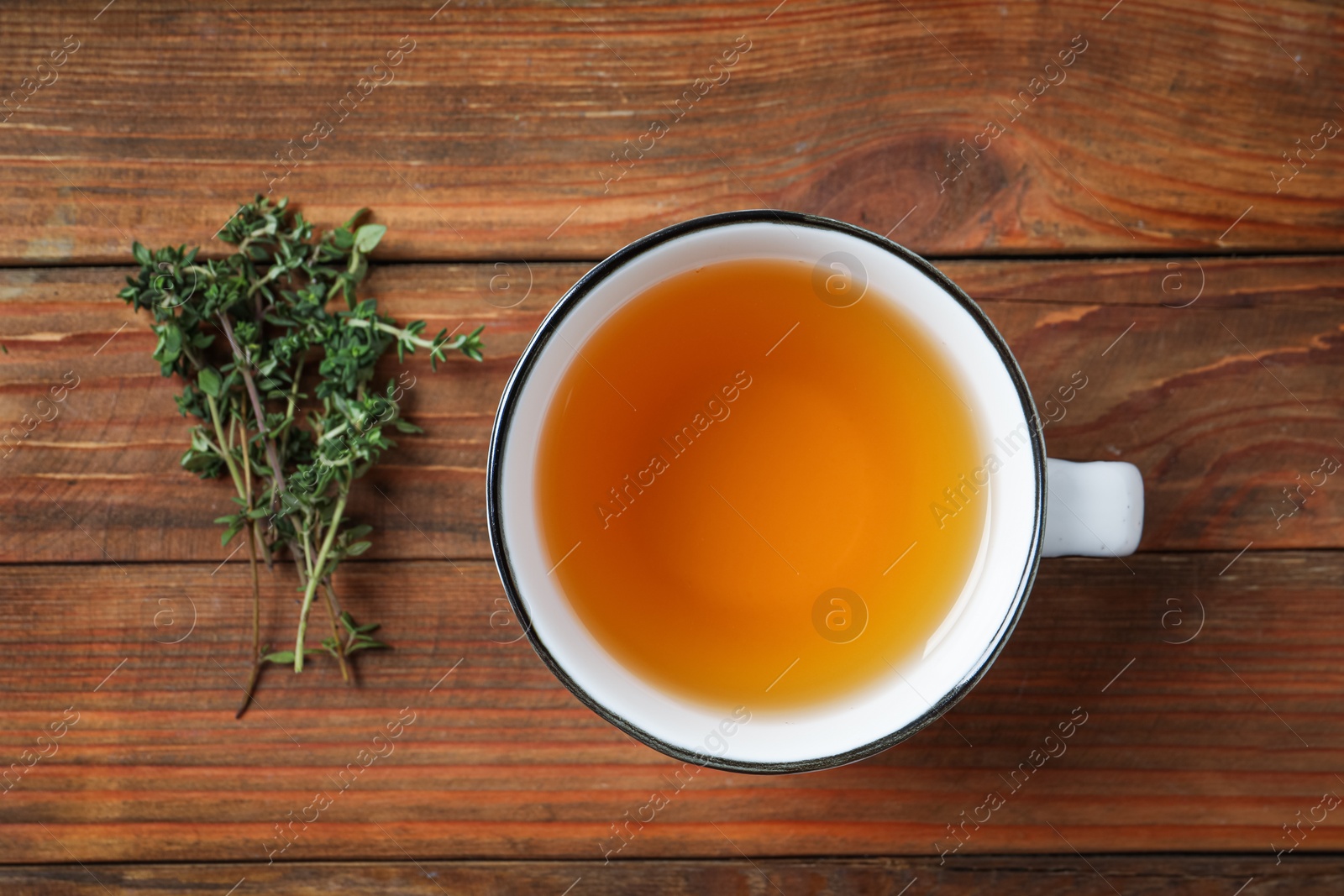 Photo of Aromatic herbal tea with thyme on wooden table, flat lay