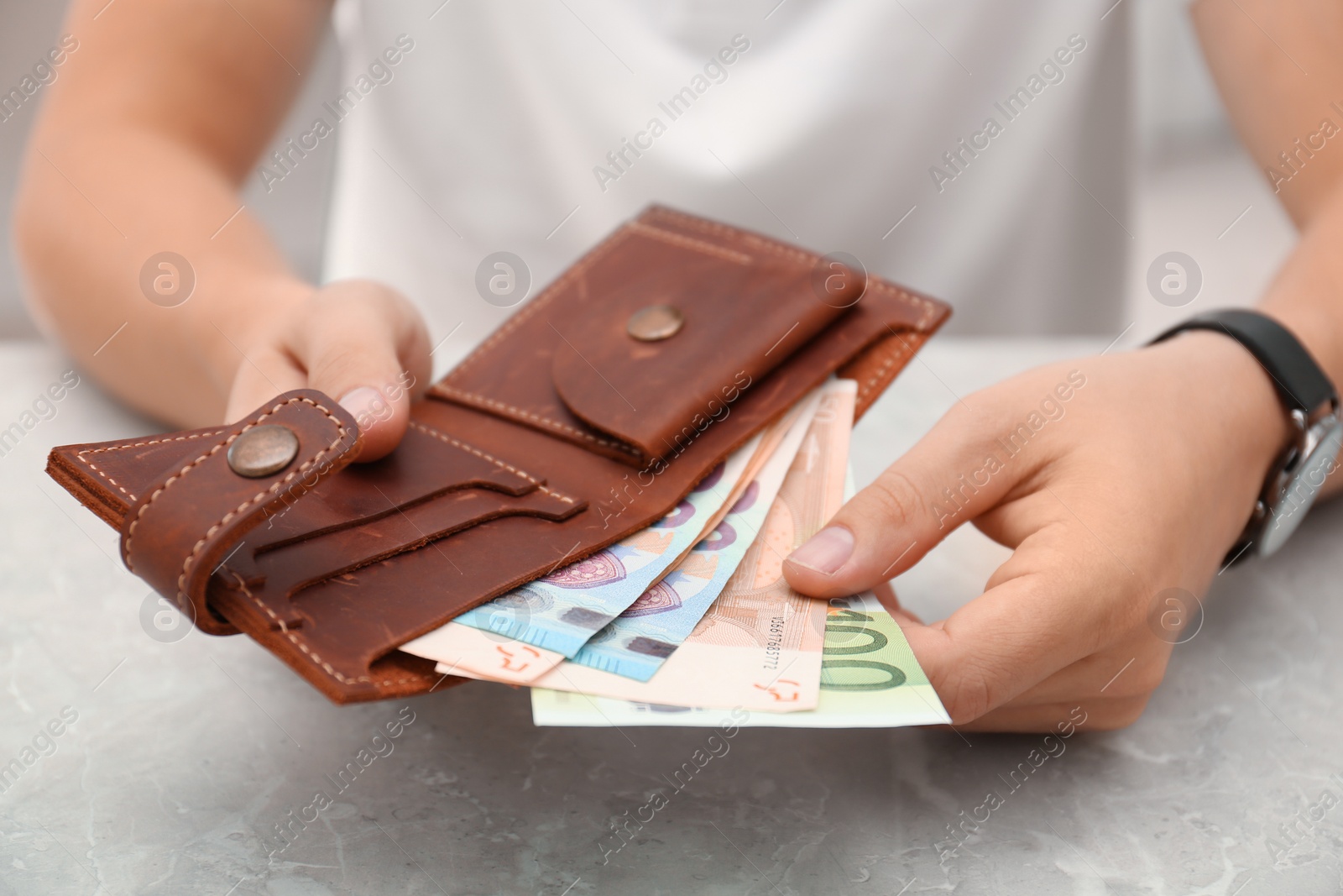 Photo of Man putting Euro banknotes in wallet, closeup