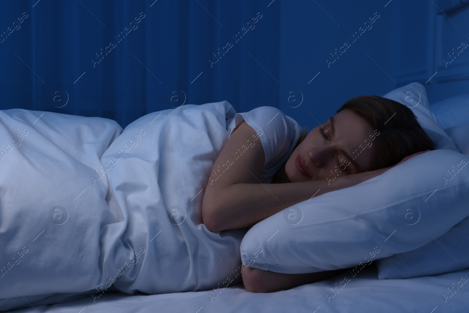 Photo of Beautiful woman sleeping in bed at night