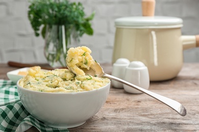 Photo of Bowl with tasty mashed potato on wooden table