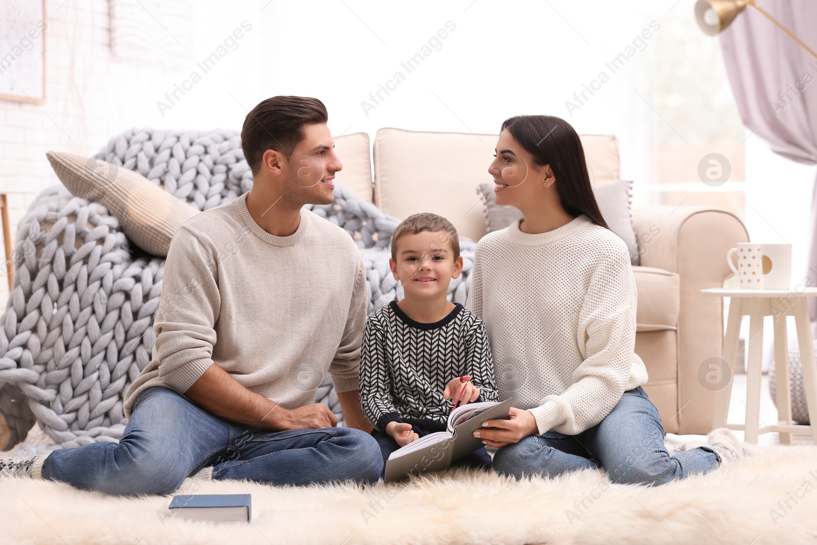 Photo of Happy family with little son reading book at home. Winter vacation